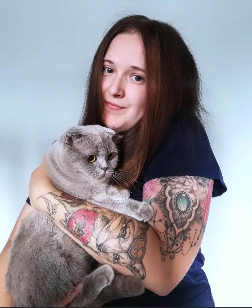 Adrianna Iwan, autorka Mikrobiologa z przypadku, trzyma szarego kota.